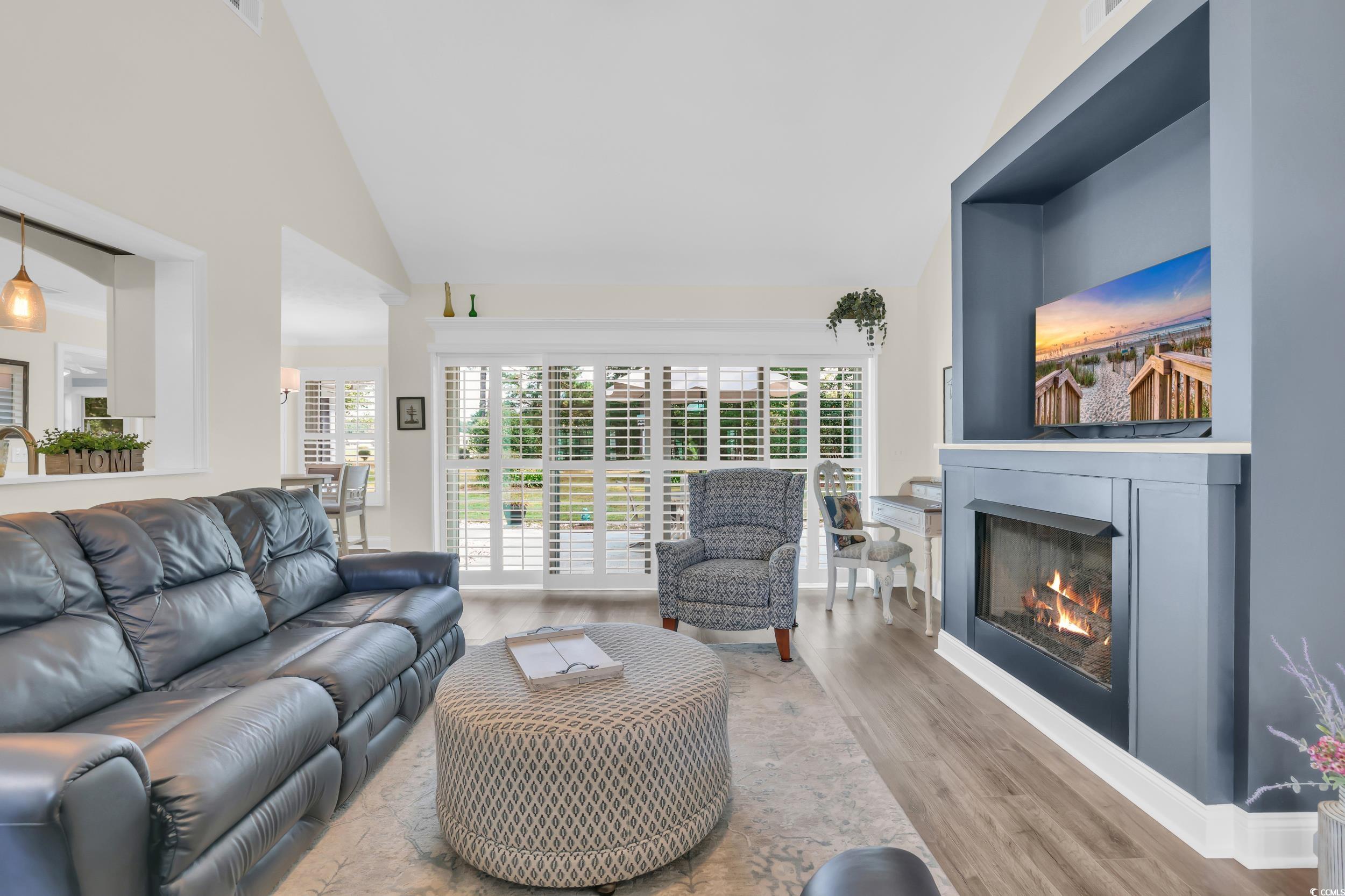 442 Deer Watch Circle Longs, SC 29568 - Photo 10 of 40 Living room featuring wood finished floors, high vaulted ceiling, and a glass covered fireplace