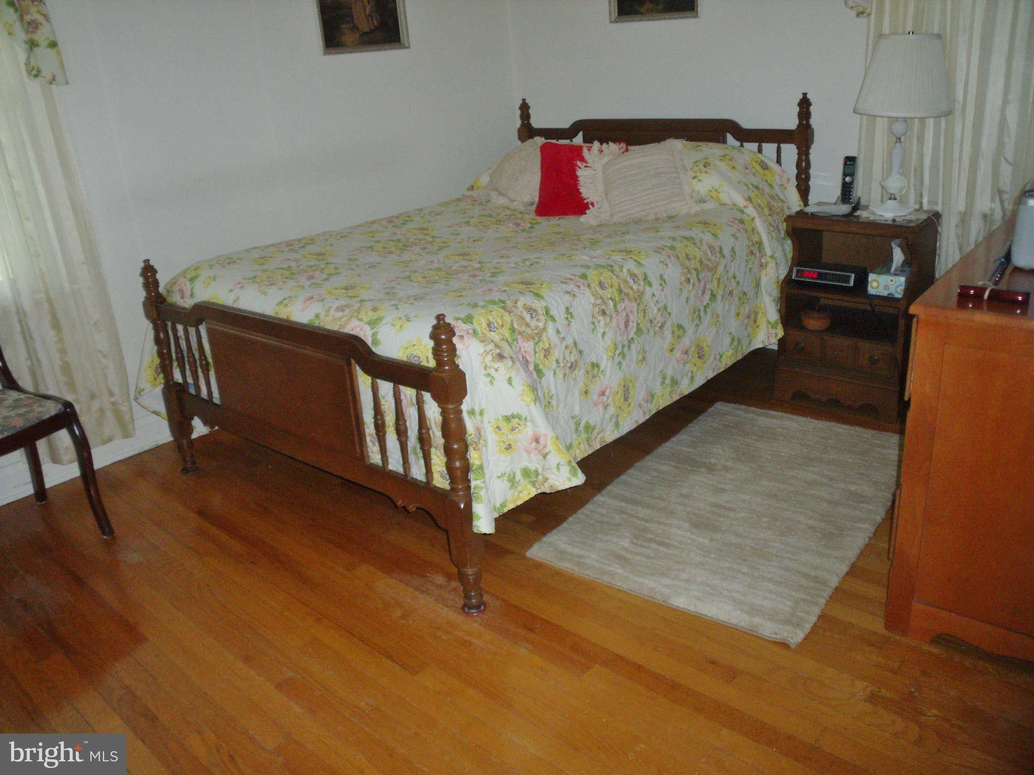 1209 Orems Road Baltimore, MD 21220 - Photo 19 of 29 a bed sitting in a bedroom next to a window with wooden floor