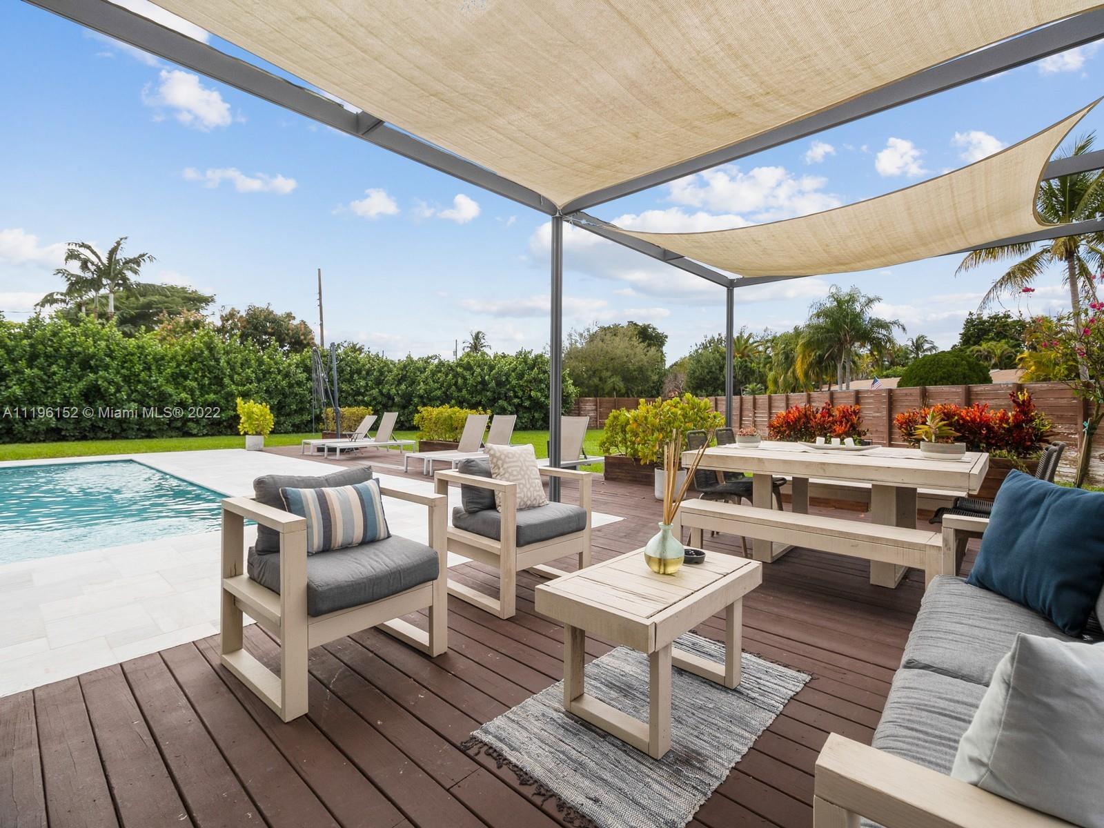 14250 Southwest 97th Avenue Miami, FL 33176 - Photo 1 of 38 a outdoor space with patio the couches and pool dining table with chairs and a table