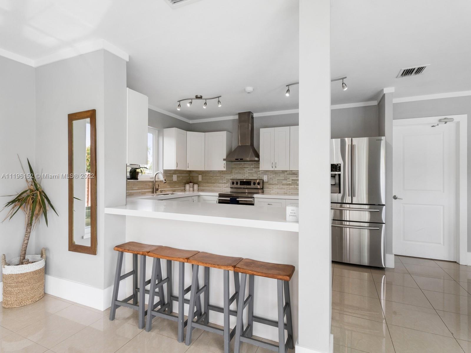 14250 Southwest 97th Avenue Miami, FL 33176 - Photo 15 of 38 a kitchen with kitchen island a refrigerator and a stove