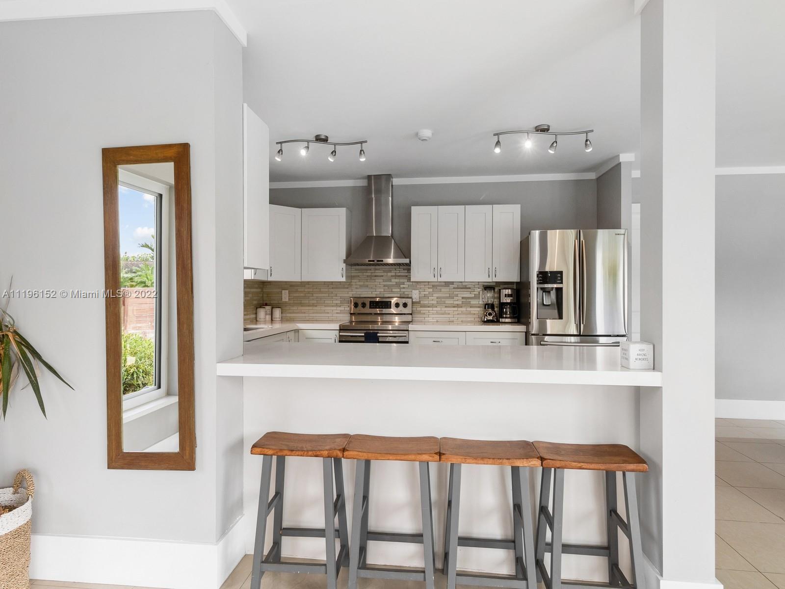 14250 Southwest 97th Avenue Miami, FL 33176 - Photo 16 of 38 a white kitchen with a sink dining table and chairs