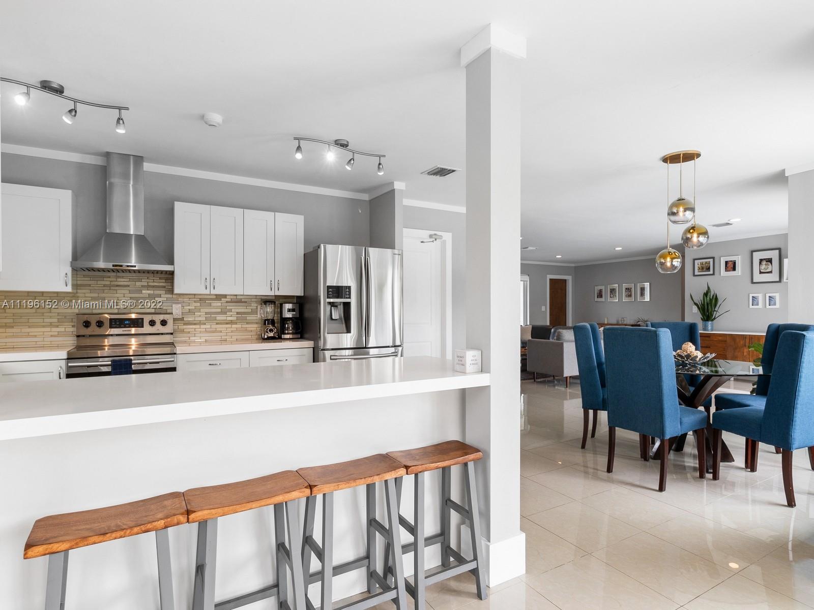 14250 Southwest 97th Avenue Miami, FL 33176 - Photo 17 of 38 a kitchen with stainless steel appliances kitchen island granite countertop a refrigerator and microwave