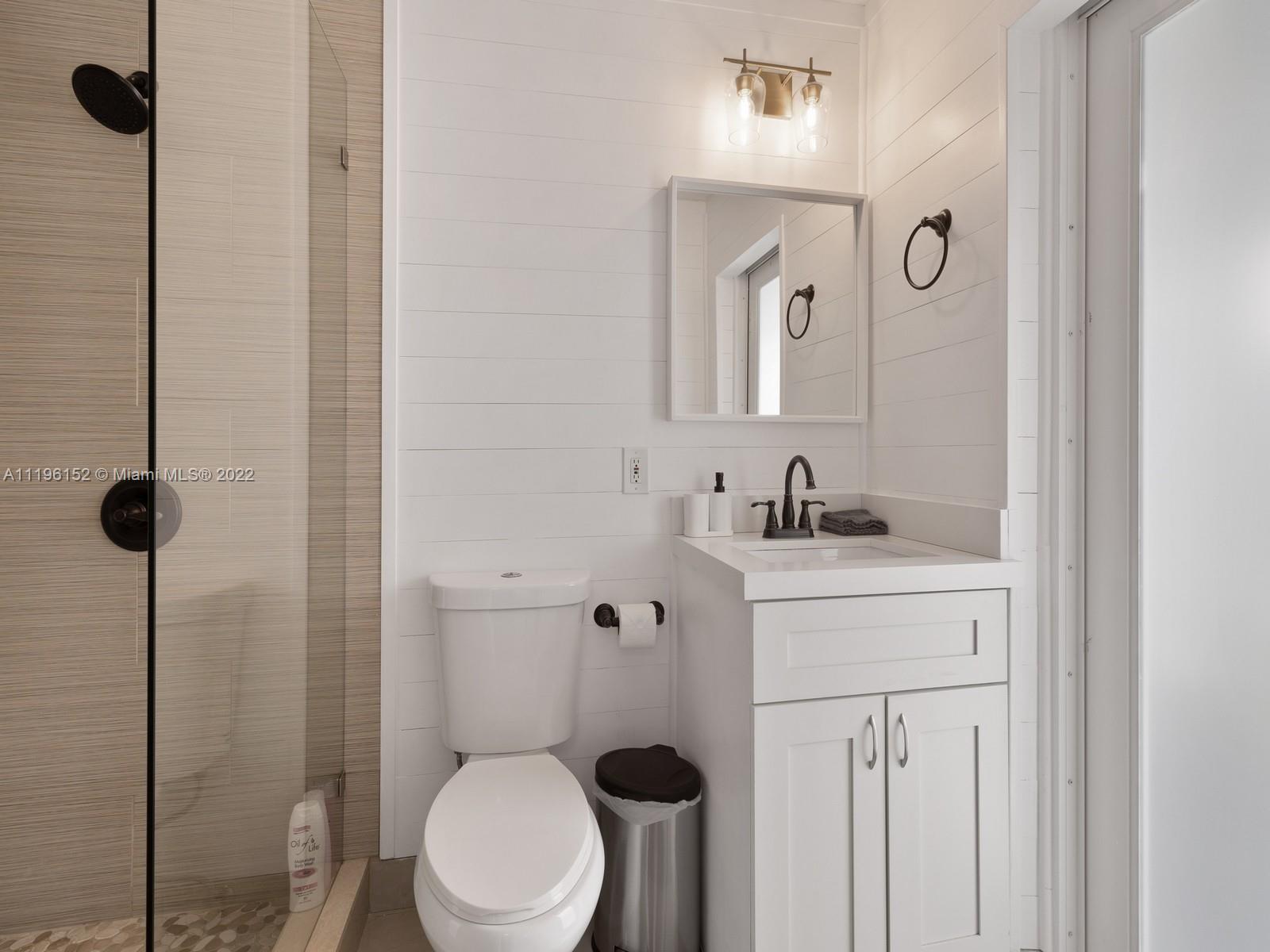 14250 Southwest 97th Avenue Miami, FL 33176 - Photo 22 of 38 a bathroom with a toilet sink a mirror and vanity