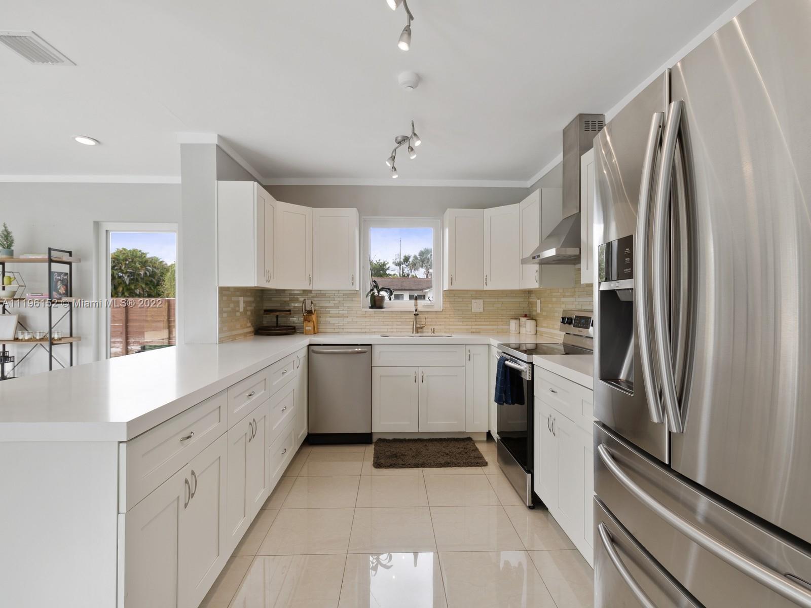 14250 Southwest 97th Avenue Miami, FL 33176 - Photo 3 of 38 a kitchen with white cabinets and stainless steel appliances