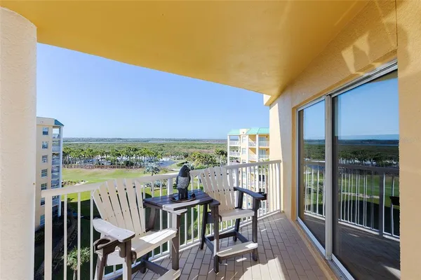 a view of a city from a balcony with furniture