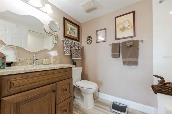 a bathroom with a granite countertop sink and a toilet