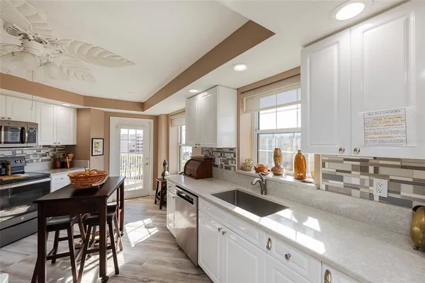 a kitchen with counter top space a sink and appliances