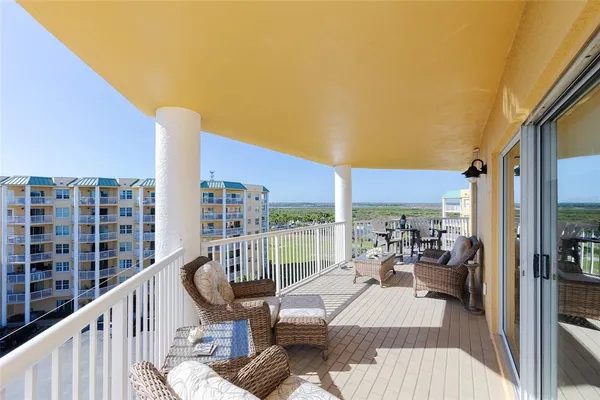 a view of a balcony with chair and wooden floor