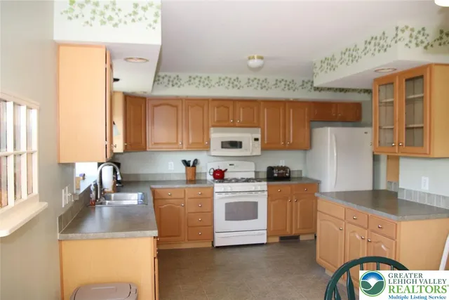 a kitchen with stainless steel appliances granite countertop a sink stove refrigerator and cabinets
