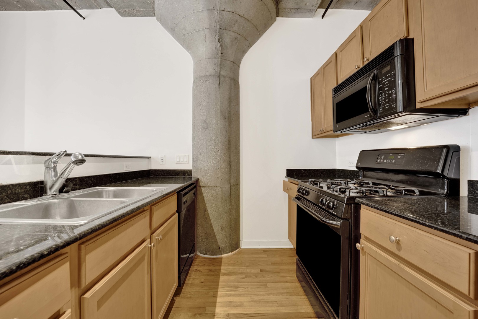 1151 West 14th Place, Unit 209 Chicago, IL 60608 - Photo 9 of 17 a kitchen with stainless steel appliances granite countertop a sink and a stove top oven