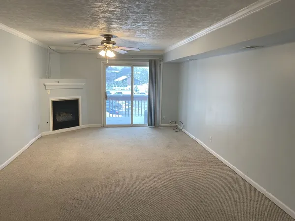 an empty room with a fireplace and windows