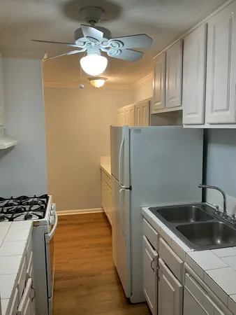 a kitchen with stainless steel appliances granite countertop a sink a stove a refrigerator a washer dryer and white cabinets