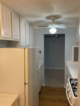 a white refrigerator freezer and a stove sitting inside of a kitchen