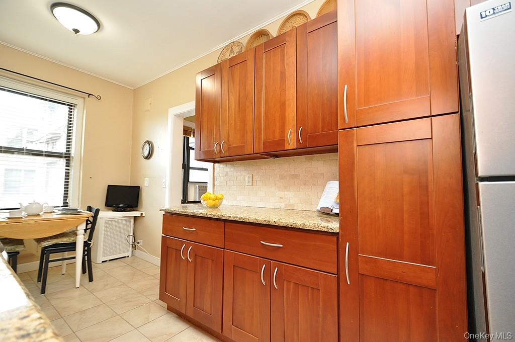 143 Garth Road, Unit 5J Scarsdale, NY 10583 - Photo 28 of 47 a kitchen with stainless steel appliances granite countertop white cabinets and sink