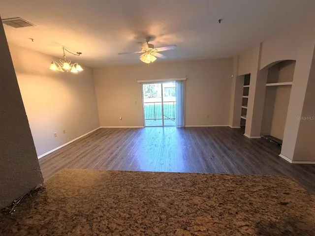 a bathroom with a granite countertop sink a toilet a mirror and shower