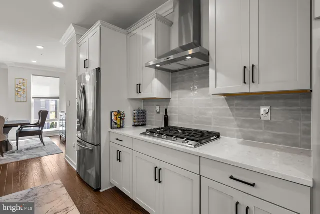 a kitchen with stainless steel appliances granite countertop a stove a refrigerator and a cabinets