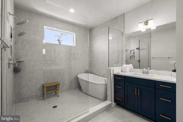 a spacious bathroom with a double vanity sink a large mirror and a bathtub