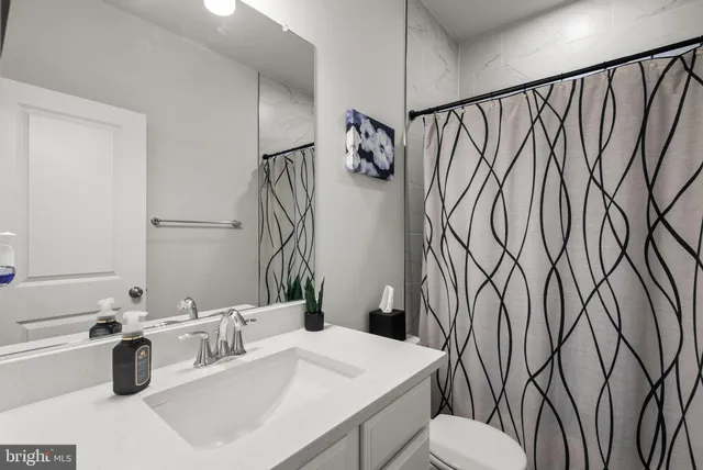 a bathroom with a sink a toilet and mirror