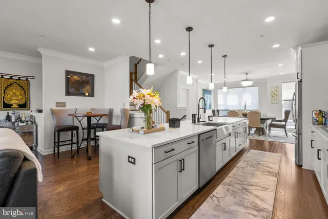 a large kitchen with stainless steel appliances kitchen island granite countertop a large island in the center