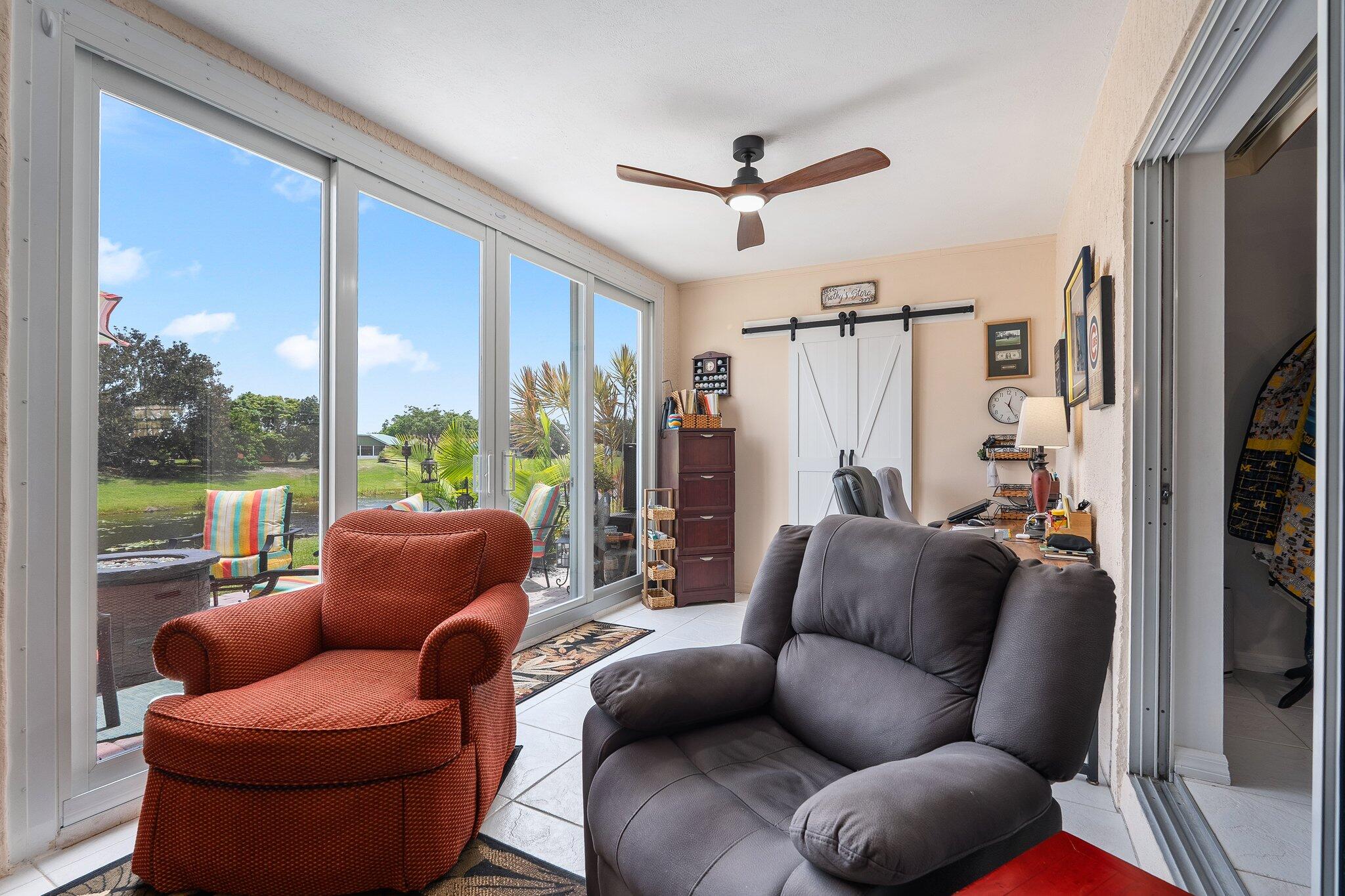 2186 Southeast Wild Meadow Circle Port St. Lucie, FL 34952 - Photo 21 of 57 a living room with furniture a ceiling fan and a window