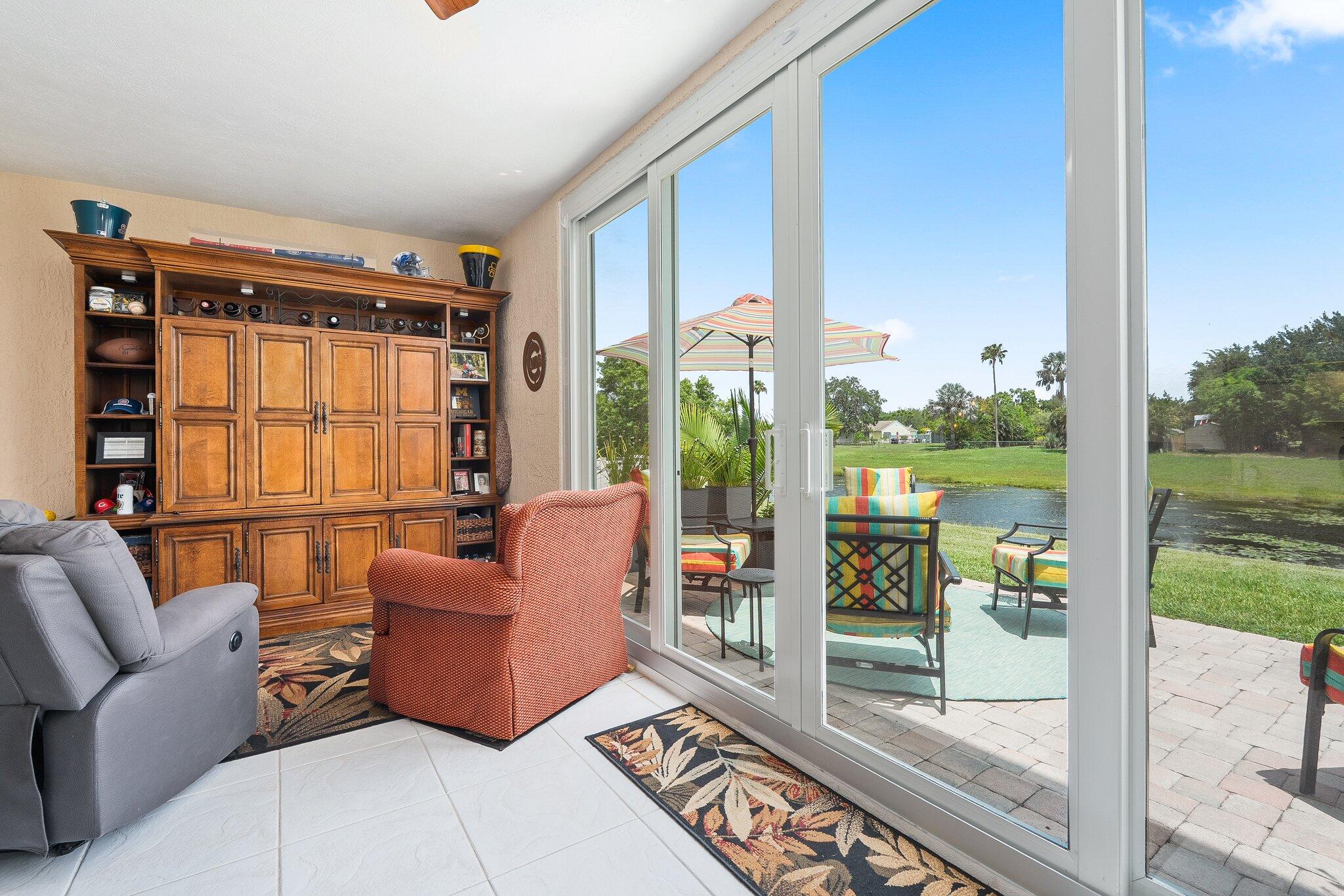2186 Southeast Wild Meadow Circle Port St. Lucie, FL 34952 - Photo 23 of 57 a living room with furniture and a floor to ceiling window