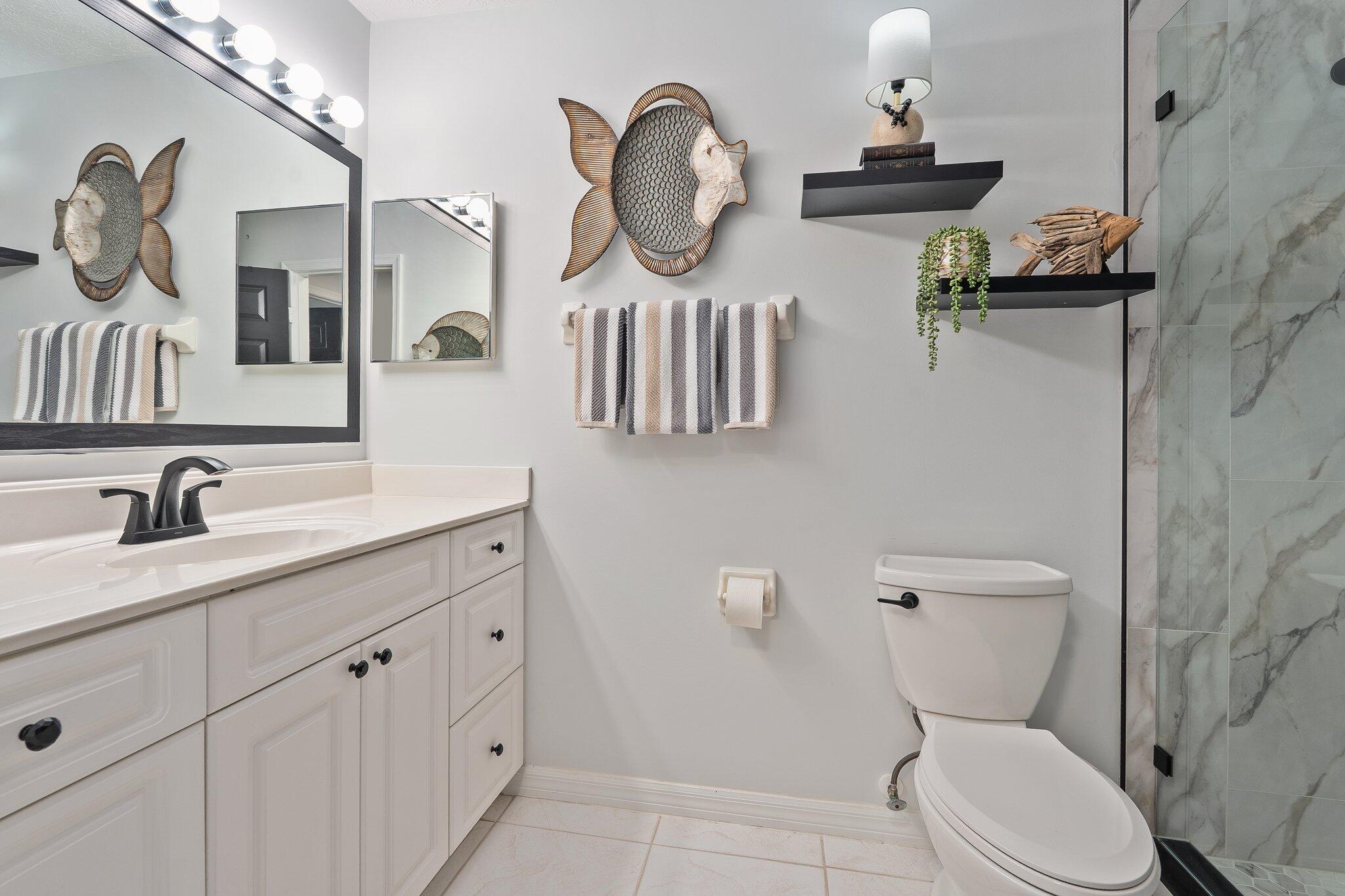 2186 Southeast Wild Meadow Circle Port St. Lucie, FL 34952 - Photo 30 of 57 a bathroom with a toilet a sink and mirror