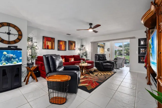 a living room with furniture a flat screen tv and a window