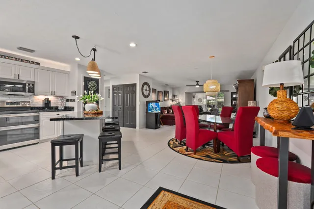 a view of a kitchen with stainless steel appliances kitchen island granite countertop a table and chairs in it