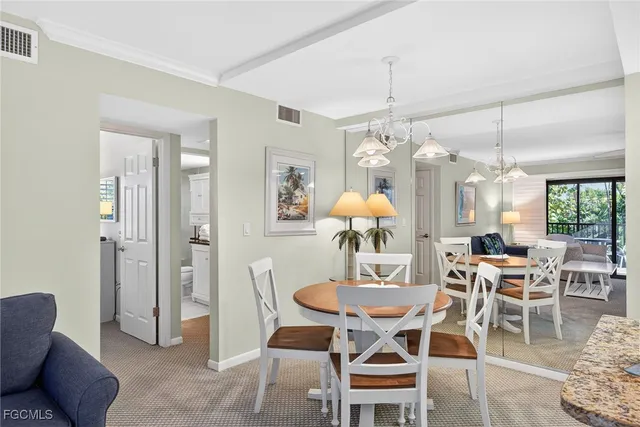 a view of a dining room with furniture and chandelier