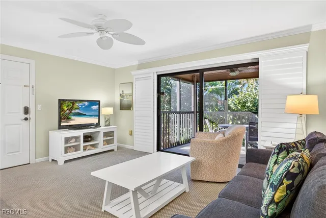 a living room with furniture a flat screen tv and a floor to ceiling window