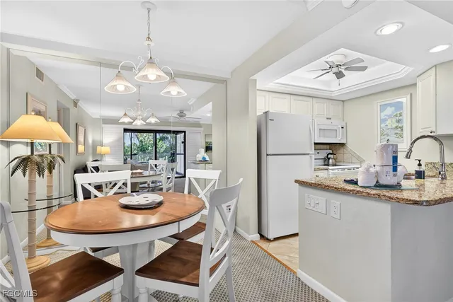 a view of a dining room with furniture a chandelier and wooden floor