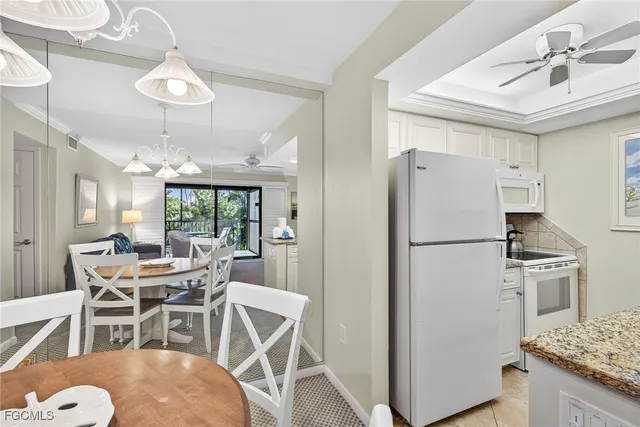 a dining room with furniture a kitchen and chandelier