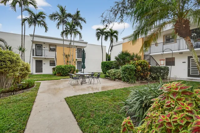 a view of a chair and table in backyard of a house