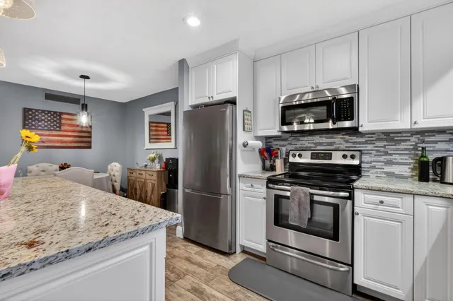 a kitchen with stainless steel appliances granite countertop a refrigerator stove microwave and sink