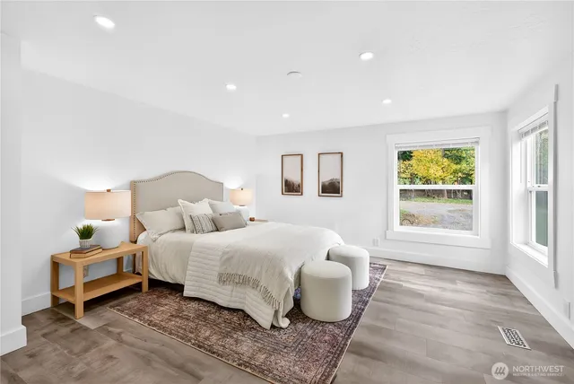 a bedroom with a bed and wooden floor