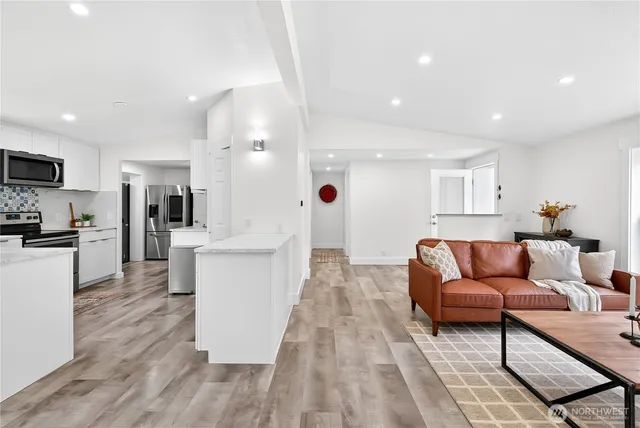 a living room with furniture and kitchen view