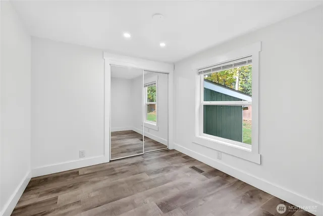 an empty room with wooden floor and a window