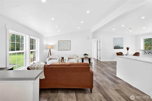 a living room with furniture a window and wooden floor