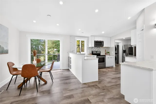 a living room kitchen with furniture and a wooden floor