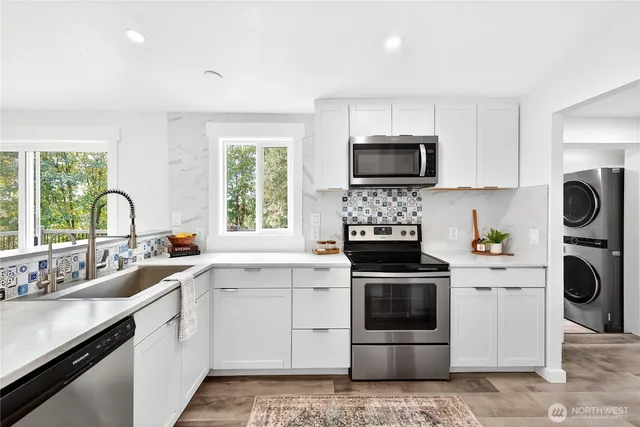 a kitchen with white cabinets and stainless steel appliances