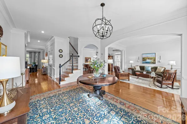 a living room with furniture a fireplace and a chandelier