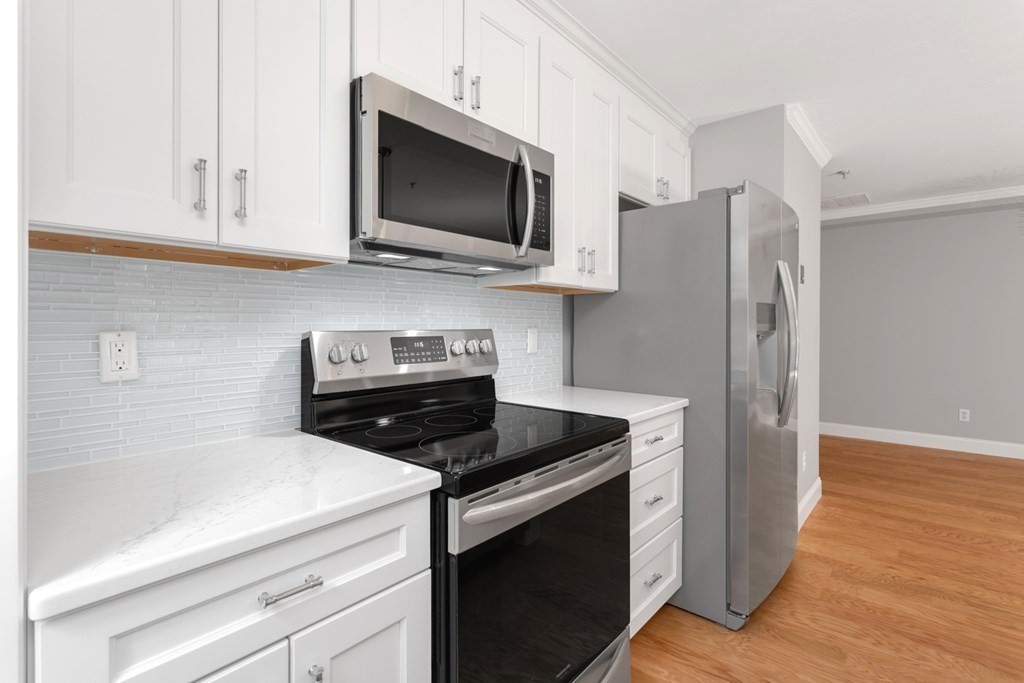 22 Forge Pond, Unit H Canton, MA 02021 - Photo 17 of 40 a kitchen with stainless steel appliances granite countertop a refrigerator stove and microwave