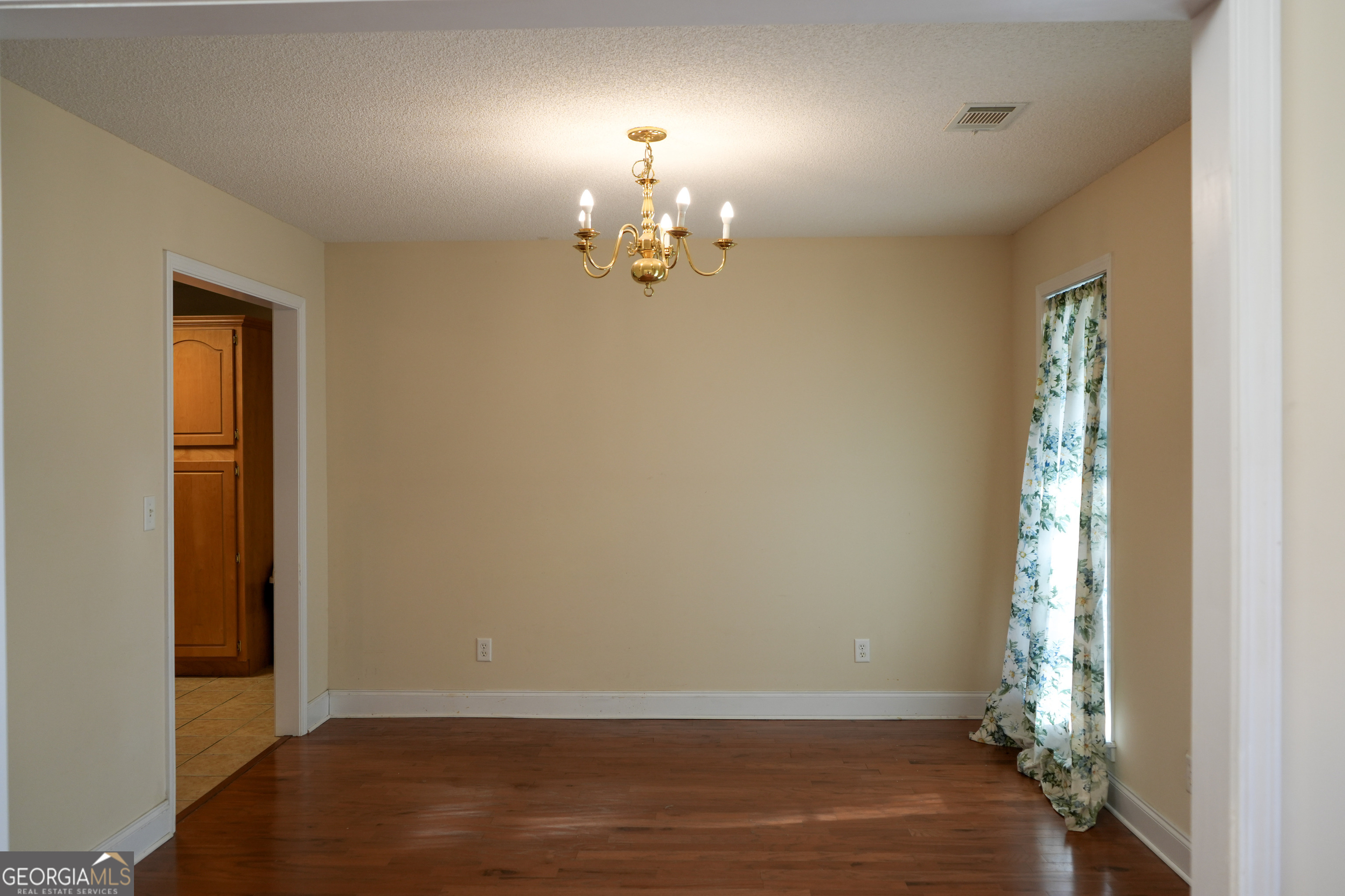 1293 Payne Road Rentz, GA 31075 - Photo 12 of 40 an empty room with wooden floor chandelier and windows