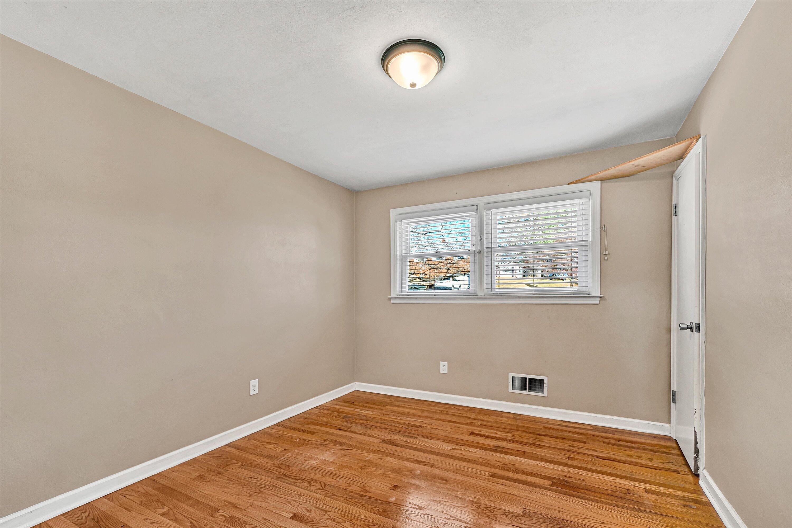 519 Doyle Street Salem, VA 24153 - Photo 15 of 40 an empty room with wooden floor and windows