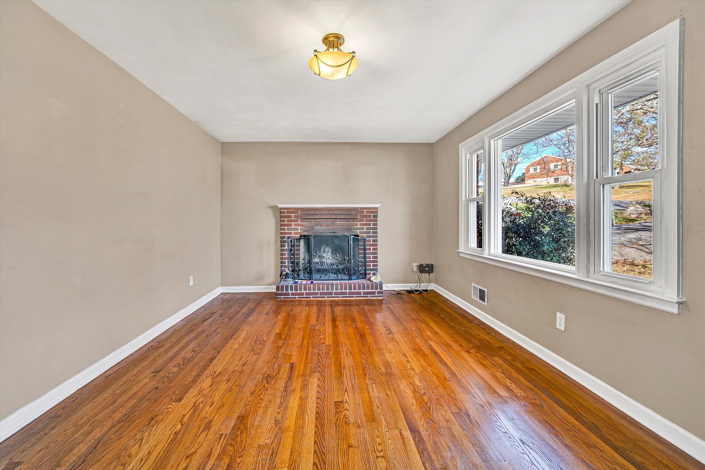 519 Doyle Street Salem, VA 24153 - Photo 6 of 40 a view of an empty room with a window and wooden floor