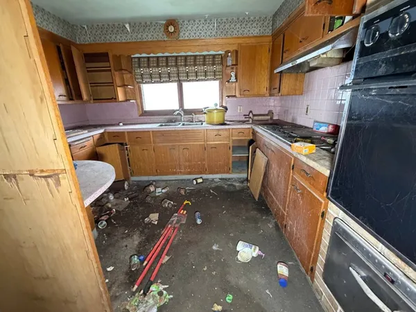 a kitchen with granite countertop a sink stove and cabinets