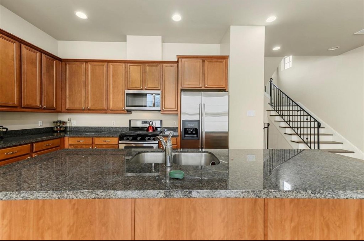 1215 Roberts Street Houston, TX 77003 - Photo 11 of 20 a kitchen with stainless steel appliances granite countertop a sink a stove and a microwave
