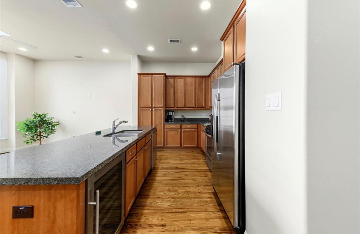 1215 Roberts Street Houston, TX 77003 - Photo 17 of 20 a kitchen with kitchen island granite countertop a sink and wooden cabinets