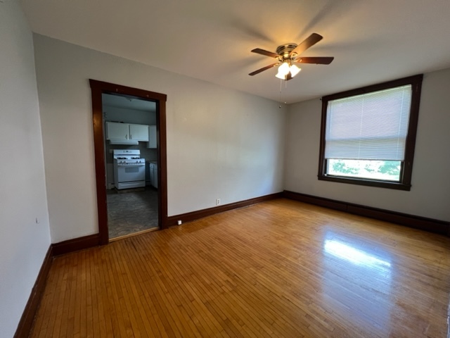 532 South Street Elgin, IL 60123 - Photo 19 of 43 an empty room with wooden floor chandelier fan and windows