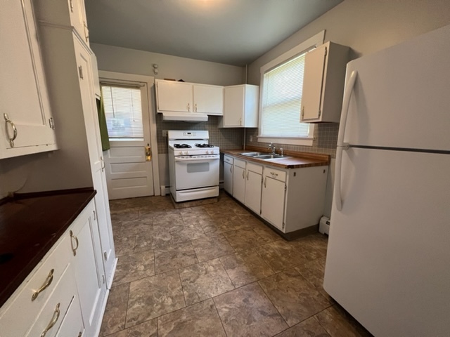 532 South Street Elgin, IL 60123 - Photo 20 of 43 a kitchen with granite countertop a refrigerator a sink a stove and white cabinets